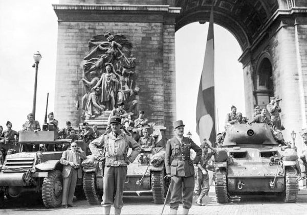 Gen. Philippe Leclerc waiting for Gen. Charles de Gaulle to begin the victory march down the Champs Élysees. Photo by anonymous (26 August 1944). Wikimedia Commons.
