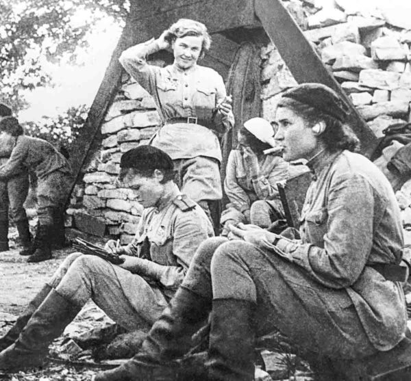 “Witches” during a break in Novorossiysk. Nadezhda Popova (standing), Irina Sebrova (sitting in the middle), and Vera Belik (foreground, smoking). Photo by anonymous (September 1943). Photo Evghenij Chaldej.