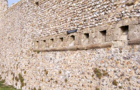 The rear view of the medieval garderobe toilets at Portchester Castle, UK, where the poop exited the castle into the moat. Photo by Colin Babb (date unknown). 