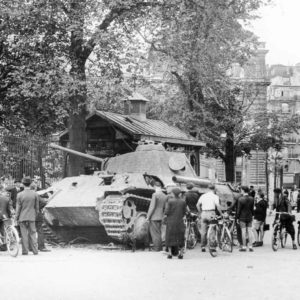 Place Paul-Claudel--view of eastern side of Luxembourg Palace (behind tank and trees), Luxembourg Gardens (left), and the rear of the Odéon Théâtre de l'Europe (extreme right-out of view). Disabled German panther tank is examined by crowds. Photo by anonymous (25 August 1944). TopFoto.
