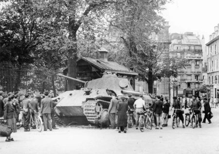 Place Paul-Claudel--view of eastern side of Luxembourg Palace (behind tank and trees), Luxembourg Gardens (left), and the rear of the Odéon Théâtre de l'Europe (extreme right-out of view). Disabled German panther tank is examined by crowds. Photo by anonymous (25 August 1944). TopFoto.