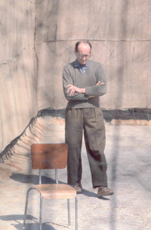 Adolf Eichmann in the exercise yard of Ayalon Prison (formerly known as Ramla Prison). Photo by anonymous (1 April 1961). National Photo Collection of Israel. PD-Expired copyright. Wikimedia Commons.