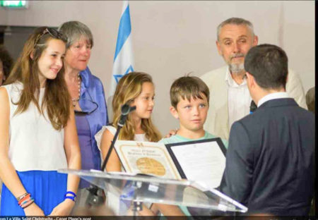 Israeli Consul performing the ceremony of recognizing Mary Elmes as “Righteous Among the Nations.” Standing in the background are Mary’s children, Caroline Danjou and Dr. Patrick Danjou. The gold medal was presented to Mary’s great-grandchildren. Photo by anonymous (c. 2013). Courtesy of Bernard S. Wilson. www.myjourneyblog919045528.wordpress.com 
