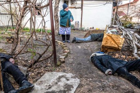 Tatiana Petrovna reacts as she views the bodies of three civilians in the garden of a home in Bucha, Ukraine. Photo by Daniel Berehulak (4 April 2022). New York Times.