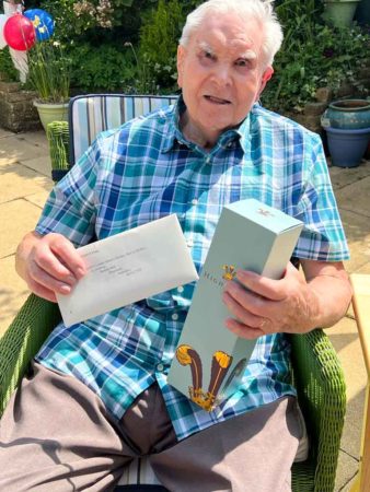Stanley holding the personal letter from Prince Charles and the gift bottle of Highgrove Champagne. Photo by Pat Vinycomb (24 April 2022).