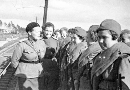 Head of the Central Sniper School’s political department (i.e., commissar) talks to women leaving for the front. Photo by V. Krasutskiy (April 1943). PD-CCA-Share Alike 3.0 Unported. Wikimedia Commons.