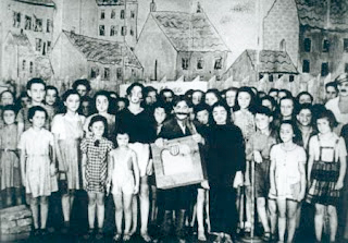 Children in the cast of “Brundibar,” a play written, produced, and performed at Terezín, 1943-44. Friedl Dicker-Brandeis’ set design can be seen in the background. Photo by anonymous (c. 1943-44). 