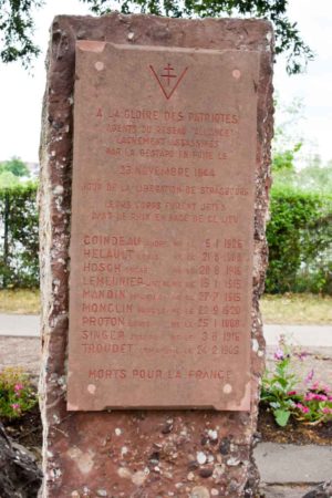 The Strasbourg memorial dedicated to nine members of réseau Alliance who were murdered by the Germans on 28 November 1944. Their bodies were dumped into the Rhine River that can be seen on the other side of the monument behind the bushes. Photo by Sandy Ross (6 June 2022).