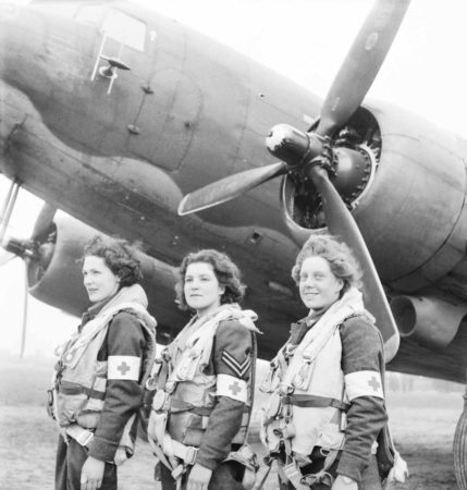 DC-3 under the command of the Royal Air Force Transport Command. Standing in front from left to right: Leading Aircraftwoman Myra Roberts, Corporal Lydia Alford, and Leading Aircraftwoman Edna Birbeck. These were the first WAAF nursing orderlies selected to fly on air-ambulance duty to France. Photo by Stanley Arthur Devon (c. 1943). Imperial War Museum. PD-U.K. public domain. Wikimedia Commons.
