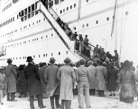 Jewish refugees arrive in Shanghai from Austria. They are disembarking from the Italian ship, “Conte Verde.” Photo by anonymous (c. December 1938). U.S. Holocaust Memorial Museum. PD-U.S. Government. Wikimedia Commons.