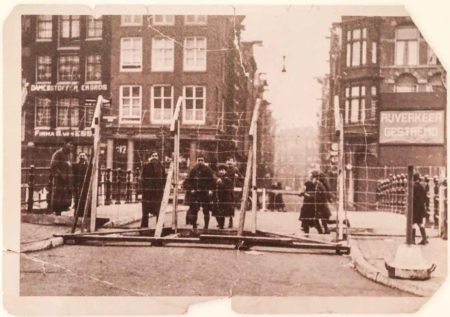 Barbed-wire fencing on Bushuissluis bridge across the Kloveniersburgwal. Behind the fence was a Jewish ghetto in Amsterdam. The Nieuwe Hoogstraat can be seen in the background. Photo by anonymous (c. 1941). Joods Historisch Museum. Wikimedia Commons.