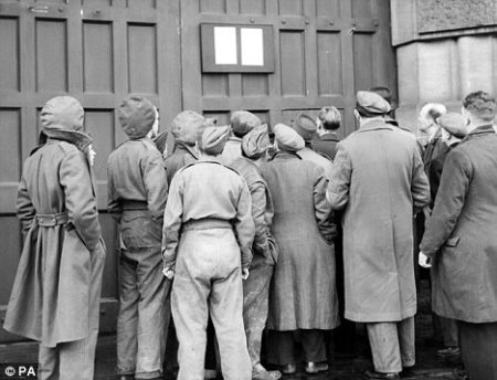 A crowd gathers to view the notice posted on the gates of Wandsworth prison, announcing the execution of John Amery at 9 o’clock on the morning of 19 December. Photo by anonymous (18 December 1945). ©️PA News.