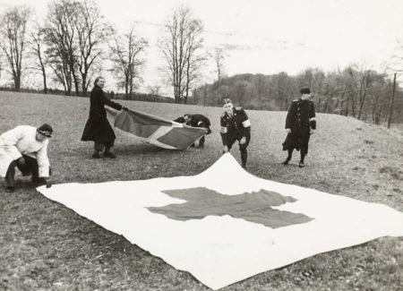 When the buses stopped on their way through Europe, a Red Cross flag was spread out on the ground to avoid bombings of the convoy. Photo by anonymous (c. April 1945). ©️The Danish Royal Library.