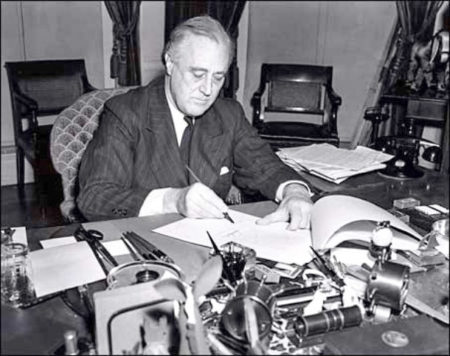President Franklin D. Roosevelt signing the Lend-Lease bill. Photo by anonymous (c. 1940). Associated Press. PD-No known copyright restrictions. Wikipedia Commons. 