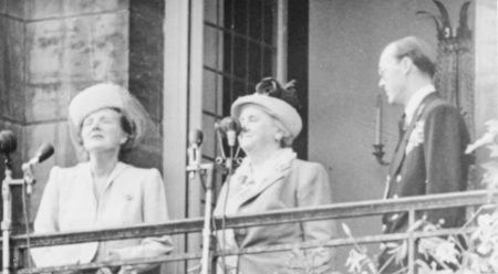 The Dutch royal family on the palace balcony immediately after Queen Wilhelmina’s abdication. Queen Julianna (left) and her husband, Prince Bernard (right) flank the former queen. Photo by Willem van de Poll (4 September 1948). Nationaal Archief NL. PD-CC0 1.0 Universal Public Domain Dedication. Wikimedia Commons.