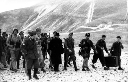 Mussolini (center in black fedora) after being rescued at Gran Sasso by a German commando unit led by Hitler’s favorite soldier, SS-Obersturmbannführer Otto Skorzeny (to the left of Mussolini in light grey uniform looking away from the camera). Photo by Toni Schneiders (12 September 1943). Bundesarchiv, Bild 101I-567-1503A-07/Toni Schneiders/CC-BY-SA 3.0. PD-CCA-Share Alike 3.0 Germany. Wikimedia Commons. 