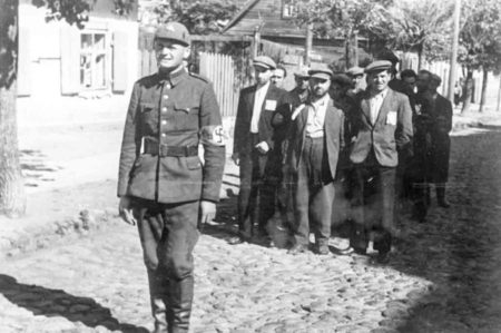 A Lithuanian soldier guarding a group of Jews in the town of Vilna.