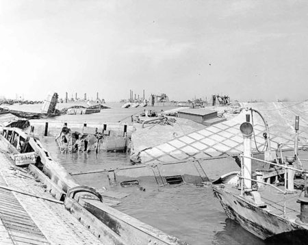 Wrecked pontoon causeway of Mulberry A artificial harbor following the storm of 19 June 1944.