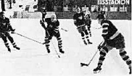 Rudi Ball (right) takes the puck down the ice in a game at St. Moritz, Switzerland.