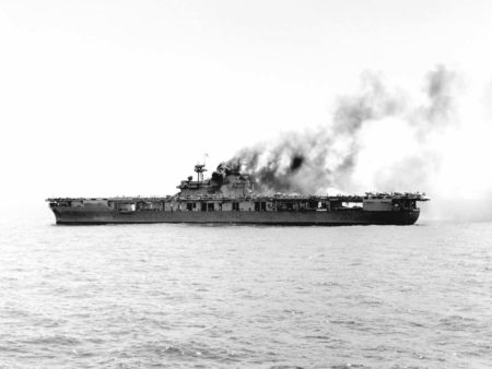 The USS Yorktown (CV-5) burning after the first attack by Japanese dive bombers during the Battle of Midway.