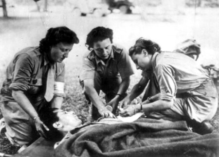 Three Rochambelles treating a wounded soldier.