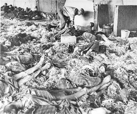 A U.S. soldier tends to a former prisoner lying among corpses of victims at the Dora-Mittelbau concentration camp, near Nordhausen, Germany.
