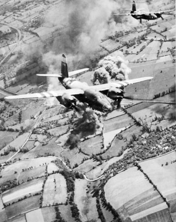 Two Marauder medium bombers of the USAAF Ninth Air Force after bombing a road and rail junction behind German lines while supporting Allied ground forces during the Normandy invasion. The plane in the center is the “Mr. Five by Five” and it was stationed at RAF Stoney Cross. This plane flew a total of 188 missions during the war with one hundred missions originating at RAF Stoney Cross. Photo by anonymous (c. June 1944). American Air Museum in Britain. PD-CC-BY-NC. https://www.americanairmuseum.com/archive/media/media-34229jpeg