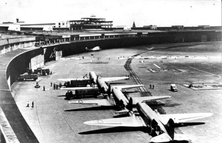 American C-47 aircraft parked in front of the terminal at Tempelhof Airport during the Berlin Airlift. Photo by anonymous (c. August 1948). PD-U.S. government. Wikimedia Commons.