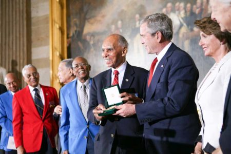 President George W. Bush (third from right) presents the Congressional Gold Medal honoring the Tuskegee Airmen at the U.S. Capitol. Lt. Col. (ret.) Harry Stewart Jr. is standing at the far left. Photo by anonymous (29 March 2007). PD-U.S. government. Wikimedia Commons.