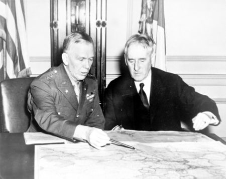 Gen. George C. Marshall, Army Chief of Staff (left) and Henry Stimson, Secretary of War (right) conferring over a map in the War Department. Photo by U.S. Army Signal Corps (c. January 1942). PD-U.S. Government. Wikimedia Commons.