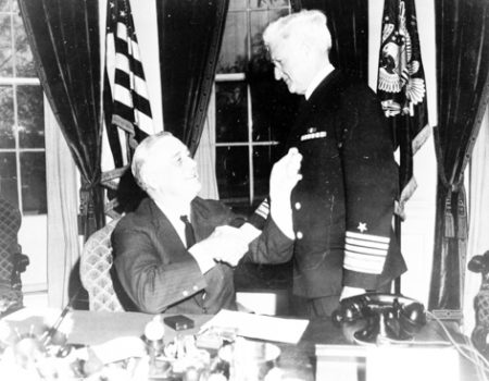 Adm. Harold R. Stark is congratulated by President Roosevelt in the White House after receiving the Gold Star. Photo by anonymous (c. April 1942). U.S. Government. Wikimedia Commons.