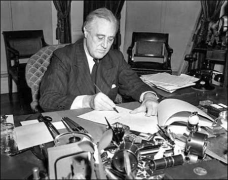 President Roosevelt signing the lend-lease bill to give aid to Great Britain, China, and Greece. Photo by anonymous (c. 1940). Library of Congress. PD-No known copyright restrictions. Wikimedia Commons.