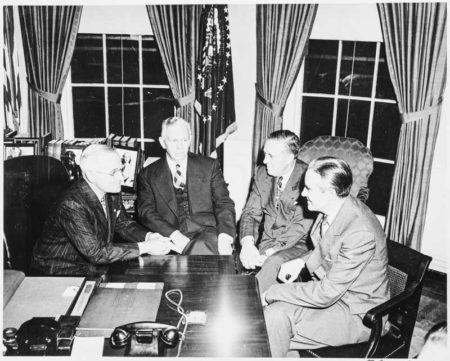 President Truman (left) discussing the Marshall Plan with Gen. George C. Marshall (second from left), Paul Hoffman (second from right), and Averell Harriman (right). Photo by Abbie Rowe (29 November 1948). National Archives and Records Administration. PD-U.S. government. Wikimedia Commons.