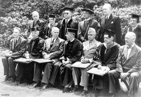Award of honorary degrees at Harvard. Seated, left to right: J. Robert Oppenheimer, Ernest Cadman Colwell, Gen. George C. Marshall, Harvard President James B. Conant, Gen. Omar Bradley, T.S. Eliot, and James W. Wadsworth Jr. Photo by anonymous (5 June 1947). PD-U.S. government. Wikimedia Commons.