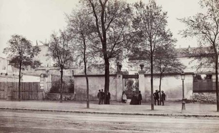 Exterior of Charles Marville’s former studio located at 66, boulevard Saint-Jacques in the 14th arrondissement. Marville can be seen in the middle in front of the arch wearing a top hat. He is talking to his life-long companion, Jeanne-Louise Leuba. This building no longer exists as it was destroyed during Haussmann’s renovations of the city. Photo by Charles Marville (c. 1865). Musée Carnavalet. PD-CC0 1.0 Universal Public Domain Dedication. Wikimedia Commons.