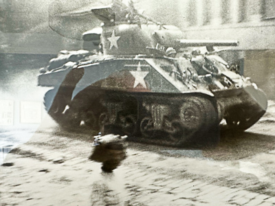 A view of an American tank rolling through the village of Einvaux. The blurred image of a young girl in the foreground is Carl’s future wife. Photo by anonymous (date unknown). Courtesy of Carl S.