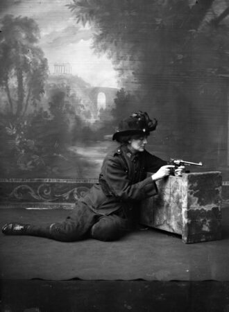 A studio photograph of Countess Constance Markievicz in uniform with a gun. Photo by anonymous (c. 1915). National Library of Ireland on The Commons. PD-Expired Copyright. Wikimedia Commons.